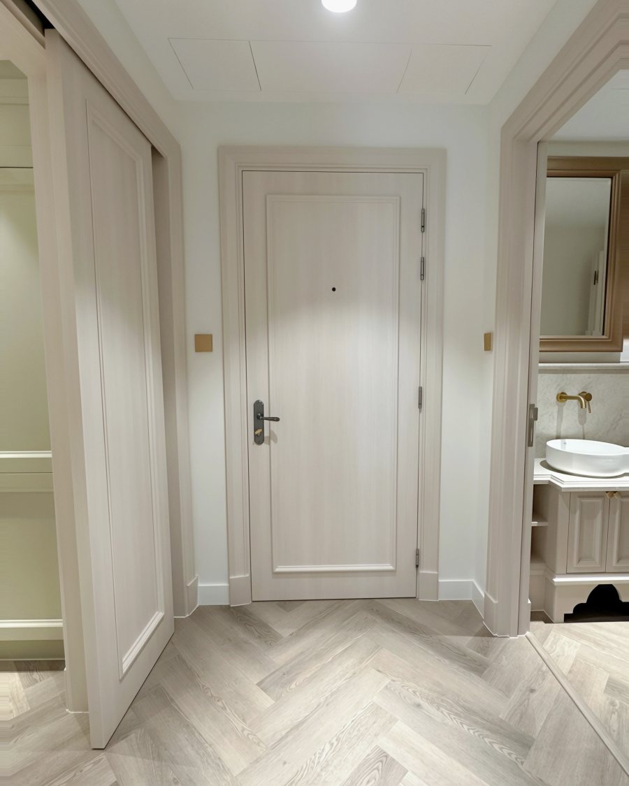 Hallway after RINOVA refinishing: pale doors, frames and herringbone floor