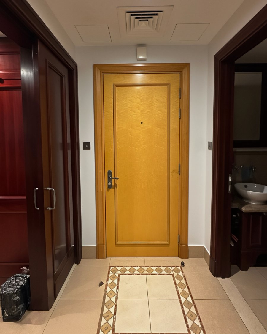 The same hallway before refinishing: dark mahogany and yellow doors